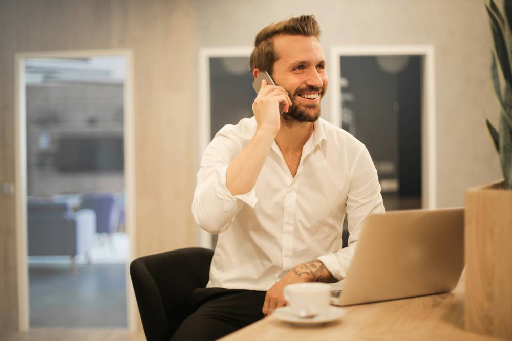 Un professionista al telefono con un cliente davanti al portatile